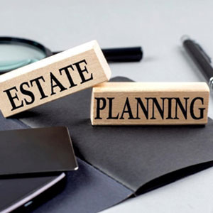 Wooden blocks with the words 'Estate Planning' on a desk with office supplies - Preston Law Group, P.C