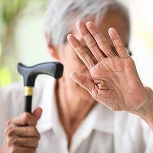 An elderly woman using a cane, representing the need for awareness and prevention of physical elder abuse in California. - Preston Law Group, P.C