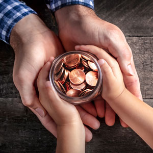 A man and a child hold a jar filled with coins, symbolizing trust administration - Preston Law Group, P.C.